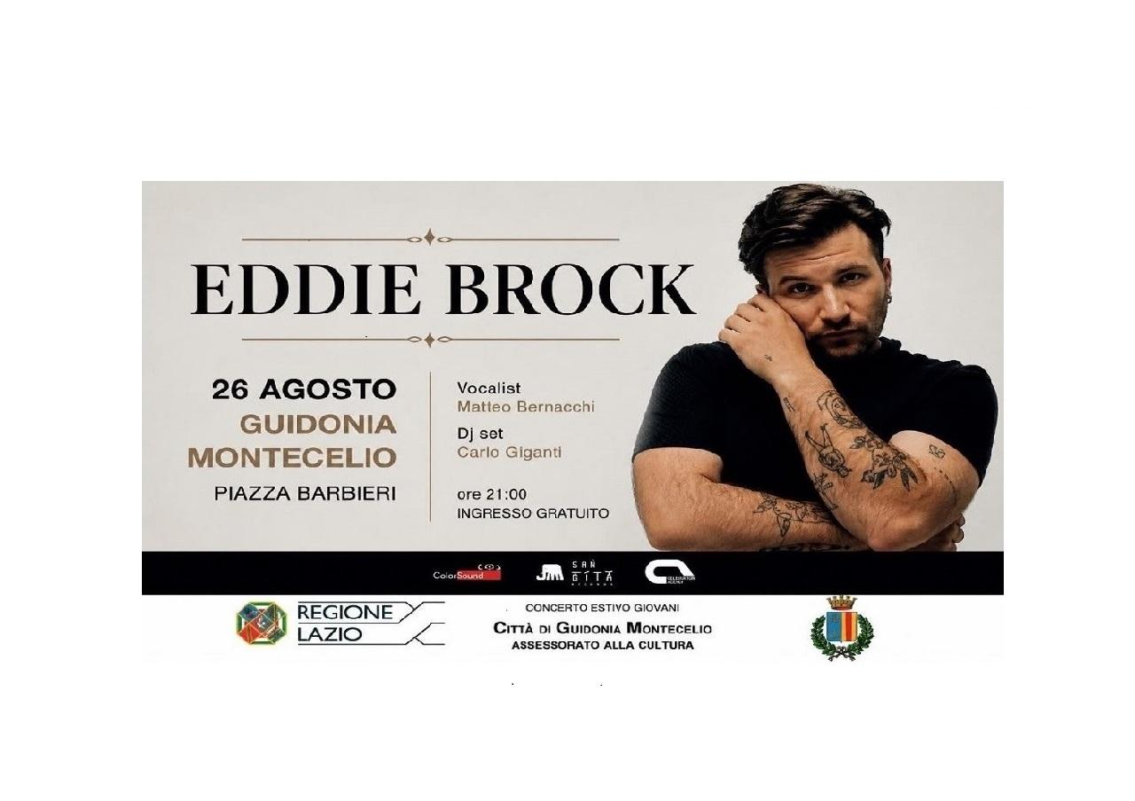 Al centro del manifesto c’è la foto del protagonista della serata Eddy Brock, con il nome in caratteri grandi. Sono indicate data, ora e luogo dell’evento: 26 agosto 2026, ora 21.00, Piazza Barbieri, Guidonia Montecelio. In basso sono presenti i loghi istituzionali: il logo della Regione Lazio, il logo del Comune di Guidonia Montecelio e la scritta Assessorato alla Cultura.